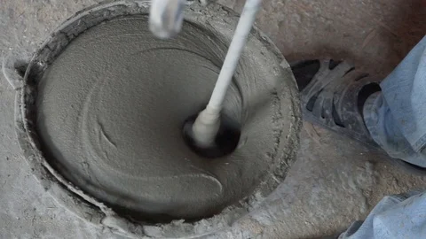 Mixing cement for construction in a small black tank. Stock-Footage 123721740
