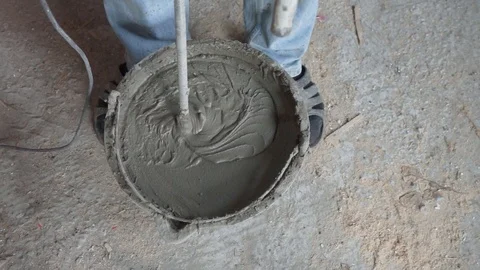 Mixing cement for construction in a small black tank. Video stock 124784582