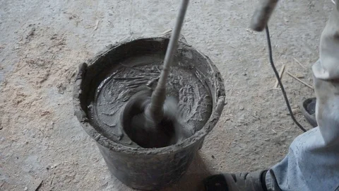 Mixing cement for construction in a small black tank. Stock-Footage 125832618