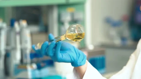 Mixing a chemical solution in a glass container during research in a scientific Stock Footage 239193236