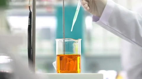 Mixing chemicals in laboratory, testing and dripping test fluid Stock Footage 147992983