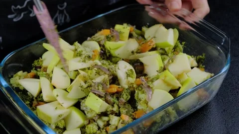 Mixing Chopped Apples and Kale in Glass Dish at Cooking Location Stock Footage 341435295