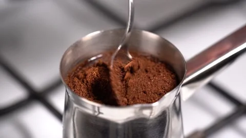 Mixing coffee with teaspoon while preparation in turkish coffee pot Stock Footage 145265145