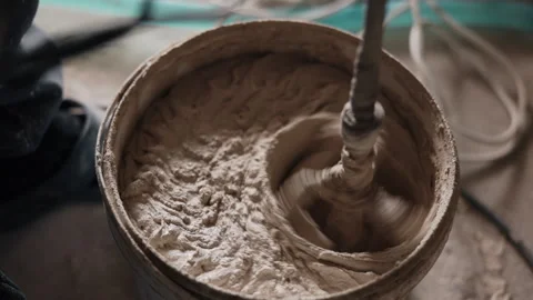 Mixing concrete plaster, Electric drill, Bucket mixing Stock Footage 330014002