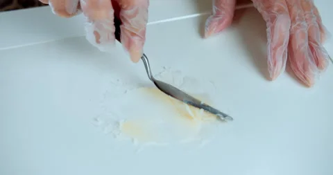 Mixing cosmetic base on white surface with spatula Stock Footage 314601809