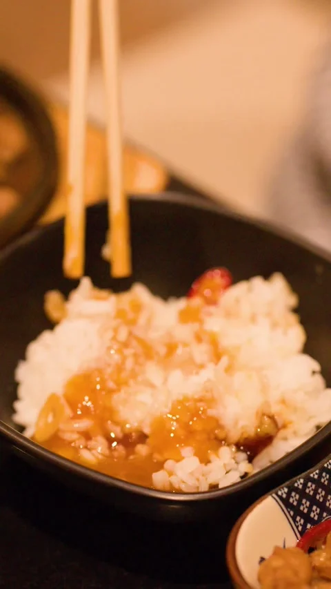 Mixing Cured Egg Yolk and Soy Sauce into White Rice with Chopsticks Stock Footage 342779533