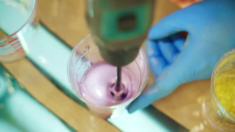Mixing dense substance in plastic cup made of transparent epoxy resin and pink Stock-Footage 263136484