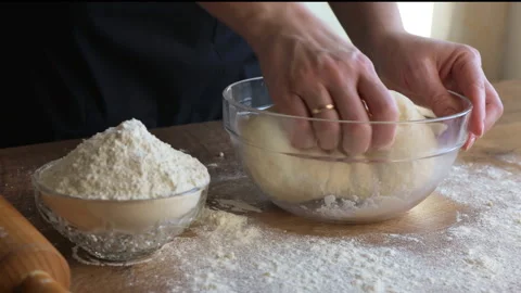 Mixing dough for baking. A woman's hand kneading dough. Stock Footage 262103120