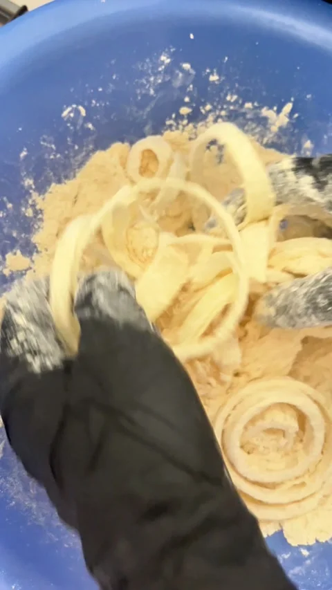 Mixing dough by hand into soft rings in a blue bowl Stock Footage 333305522