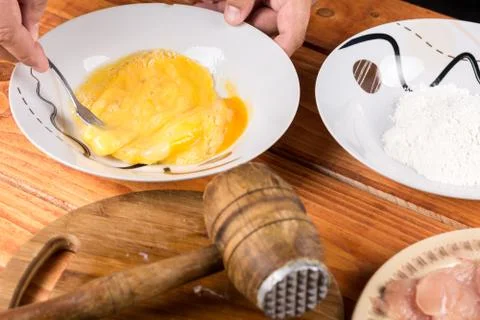 Mixing eggs in the plate with ingredients on the table Stock Photos