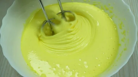 Mixing eggs with sugar using hand mixer, top view. Video stock 233518670