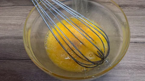 Mixing eggs with whisk for making omelette Stock Footage 164158595