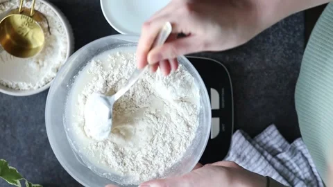 Mixing flour and water for baking bread, making or feeding sourdough starter at Stock Footage 272812129