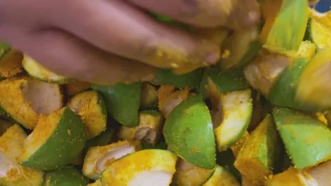 Mixing fresh chopped green mango slices with turmeric powder for traditiona.. Stock Footage 337702772