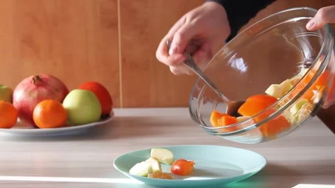 Mixing fresh fruit salad with apples,tangerines and persimmon. Stock Footage 144358498