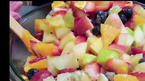 Mixing Fresh Fruit Salad in Large Glass Bowl Stock Footage 345102340