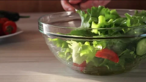 Mixing fresh vegetables salad with cherry tomatoes, cucumbers and leaf lettuce. Stock Footage 144792873