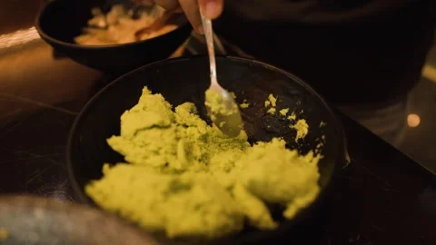 Mixing Fresh Wasabi Paste in a Black Bowl by Hand Stock Footage 321573343
