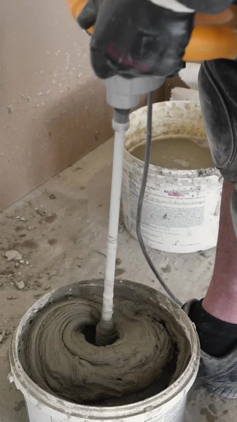 Mixing the glue solution in a bucket with a construction mixer Stock Footage 317902085