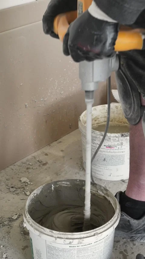 Mixing the glue solution in a bucket with a construction mixer Stock Footage 317902090