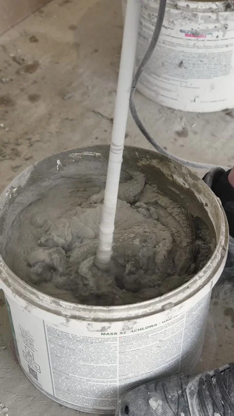 Mixing the glue solution in a bucket with a construction mixer Stock Footage 317902092