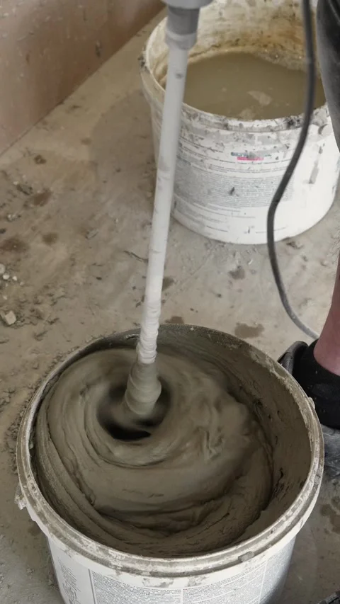 Mixing the glue solution in a bucket with a construction mixer Stock Footage 317902115