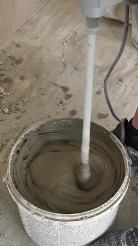 Mixing the glue solution in a bucket with a construction mixer Stock Footage 317902201
