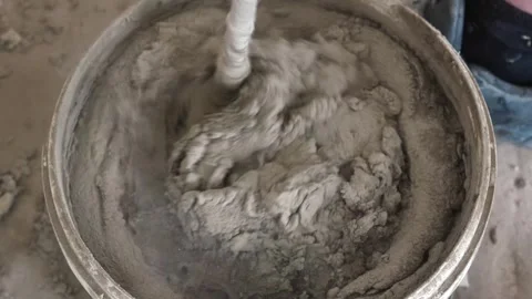 Mixing the glue solution in a bucket with a construction mixer Stock Footage 317902202