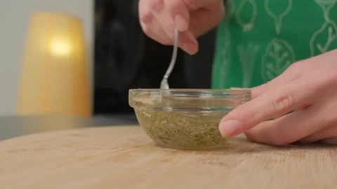 Mixing Green Herb Paste in Glass Bowl at Cooking Location Stock Footage 341462364