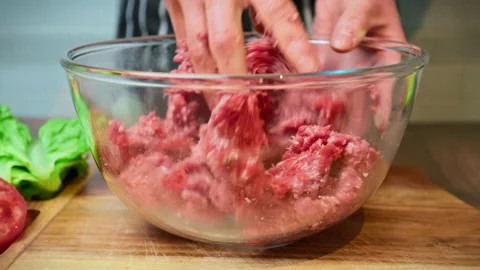Mixing with the hands grind beef mince in a transparent glass bowl in 4K. Stock Footage 153727398