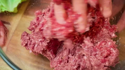 Mixing with the hands grind beef mince in a transparent glass bowl in 4K. Video stock 153728113