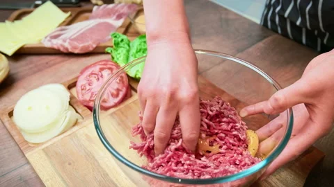 Mixing with the hands grind beef mince in a transparent glass bowl in 4K. Video stock 153728166