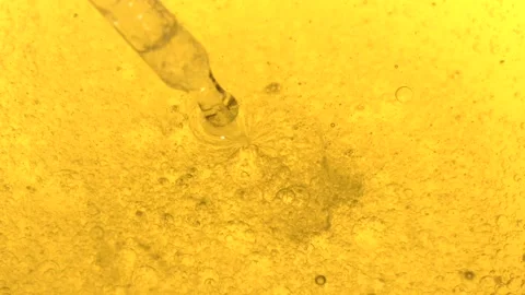 Mixing liquid in a clear container with bubbles forming in bright yellow Stock Footage 323147807