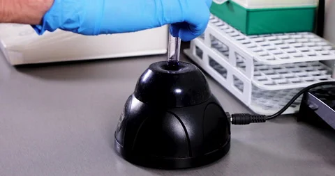 Mixing a liquid in a tube using a vortex mixer. Stock Footage 172398601