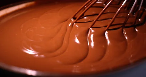 Mixing melted milk chocolate wit a corolla. Preparing chocolate sauce for Stock Footage 155334196