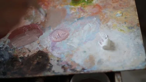 Mixing paint on palette, close-up. a painter with a long brush made of natural Stock Footage 74243972