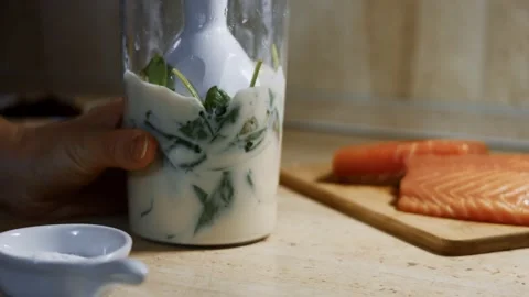Mixing pancake batter and fresh spinach leaves with a hand blender. Process of Stock Footage 144902966