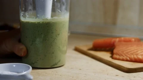 Mixing pancake batter and fresh spinach leaves with a hand blender. Process of Stock Footage 144903080