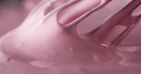 Mixing pink cream for dessert in a kitchen bowl during afternoon baking session Stock Footage 325088061