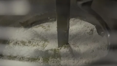 Mixing process of flour and liquid ingredients in a stainless steel bowl with a Vídeo Stock 331755424