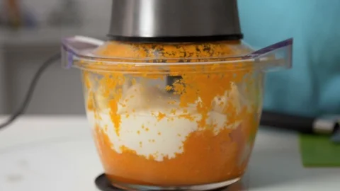 Mixing pumpkin with yogurt in chopper in the kitchen Stockbeeldmateriaal 122516565