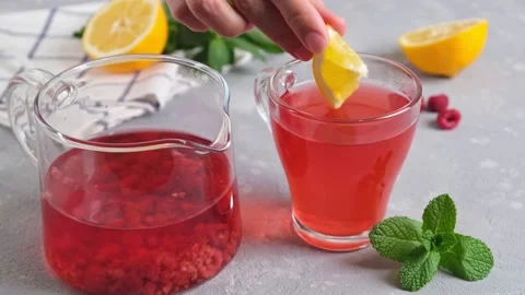 Mixing raspberry tea with lemon with spoon. Slow motion. Stock Footage 153035050