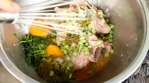 Mixing raw minced pork with egg and vegetables in bowl, in door  Chiangmai  Thai Stock Footage 132719814