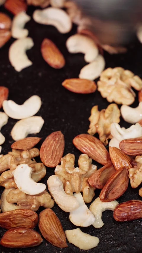 Mixing raw nuts for roasting in a pan or cauldron or wok. Stock Footage 282567440