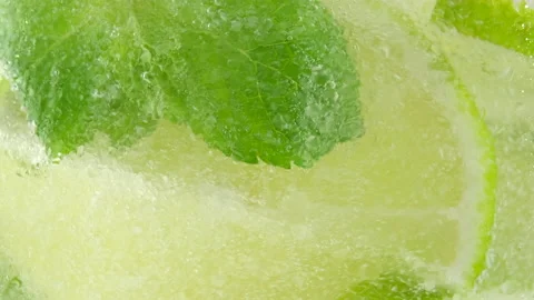 Mixing refreshing drink with lime, sparkling water, mint closeup Stock-Footage 135593774