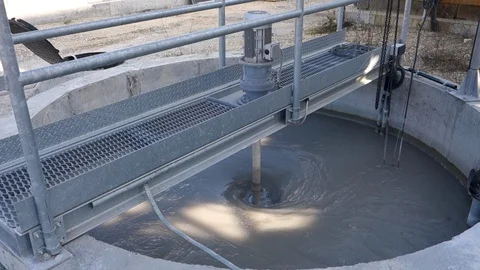 Mixing sand and crushed stone to produce concrete in a large tank Stock Footage 94932905