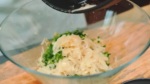 Mixing shredded cabbage and dill in glass bowl in kitchen Stock Footage 342889310
