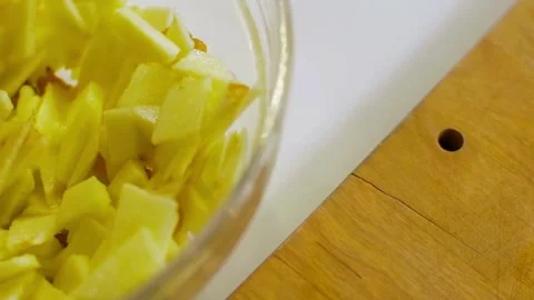 Mixing sliced apples with cinnamon spice in glass bowl Video stock 333833178