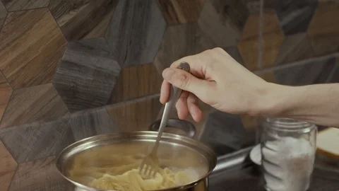 Mixing spaghetti in pan Stock Footage 126472020