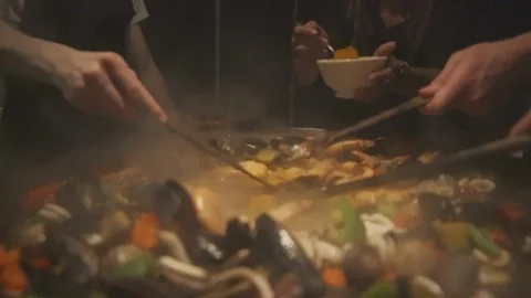 Mixing in the spices for paella Stock Footage 100393918